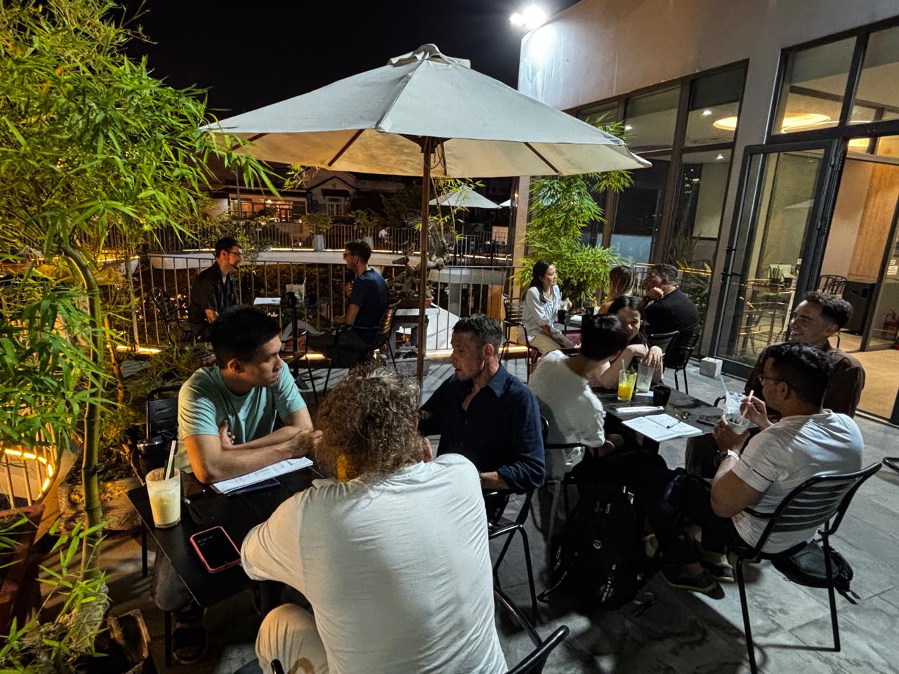 Members talking in relaxed small groups at the Friday, April 10, 2026 language exchange in Da Nang.