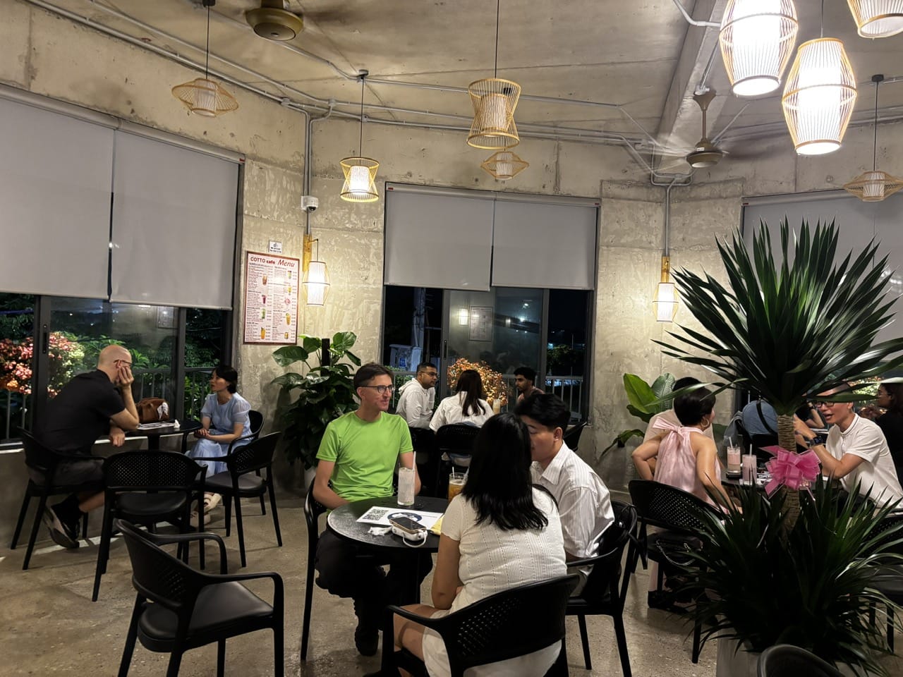Active small-group conversations across the cafe during the Friday, March 27, 2026 session.