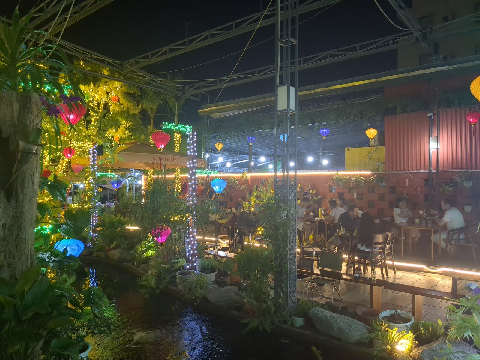 A wide courtyard view of the Friday, April 3, 2026 language exchange at An Hoi Cafe.